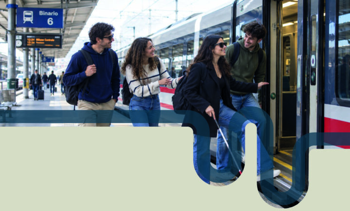 Due ragazzi e una ragazza aiutano una ragazza ipovedente a salire su un treno